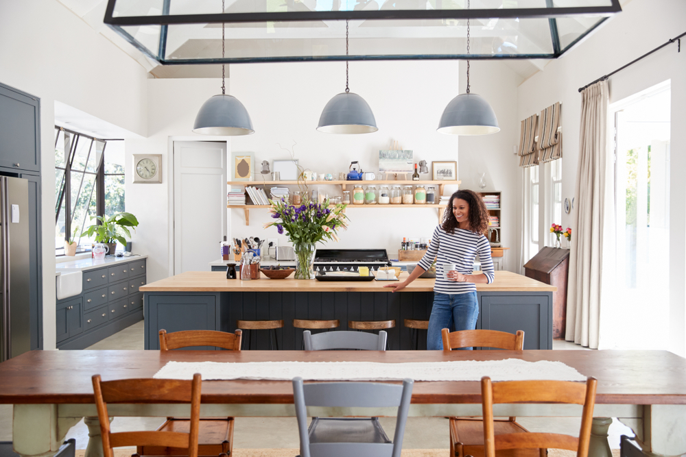 Young woman standing in newly remodeled modern kitchen.