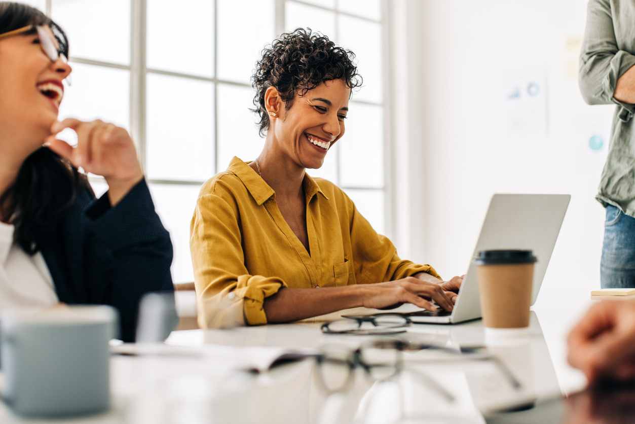 Young professional smiling while using computer in office.