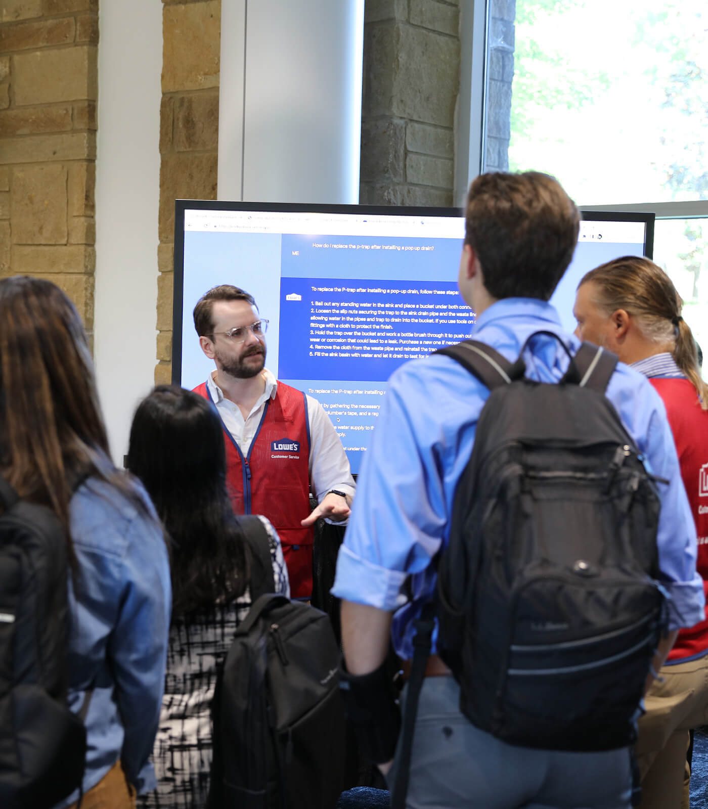Male Lowe's Innovation Labs team member speaking to a group of people about generative ai. 