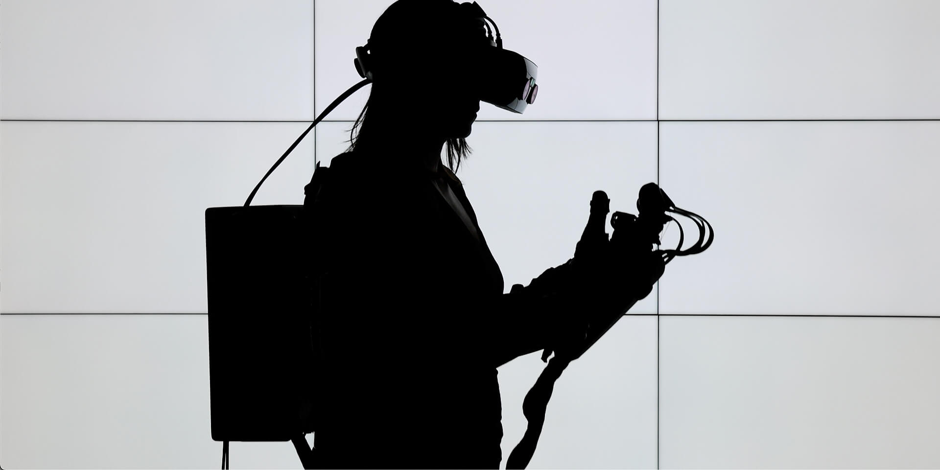 Silhouette of female Lowes Innovation Labs team member wearing haptics enabled gloves with tactile feedback. 