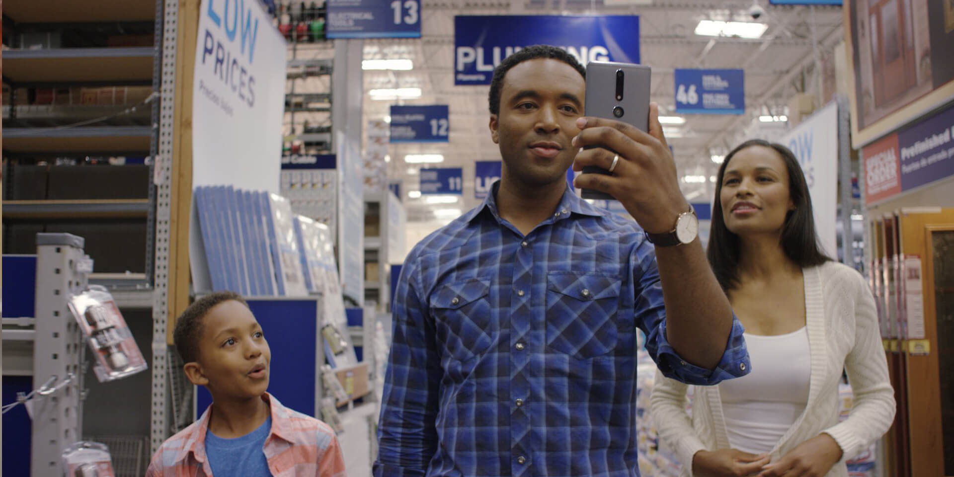 African-American family in a Lowes Home Improvement store using in-store navigation to find what they need.