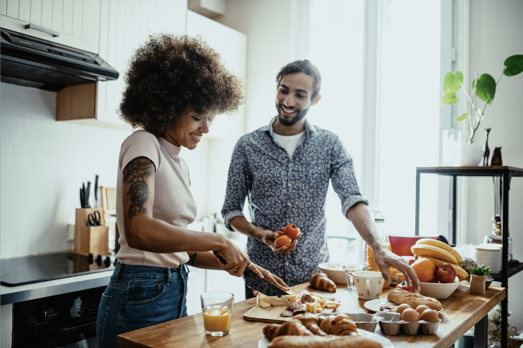 Couple in kitchen talking about buying their first investment home.